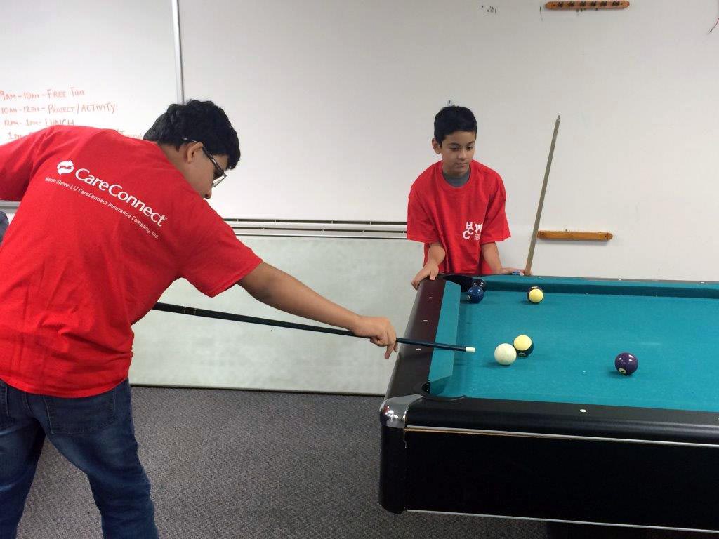 Teens play pool at the Teen Drop in Center